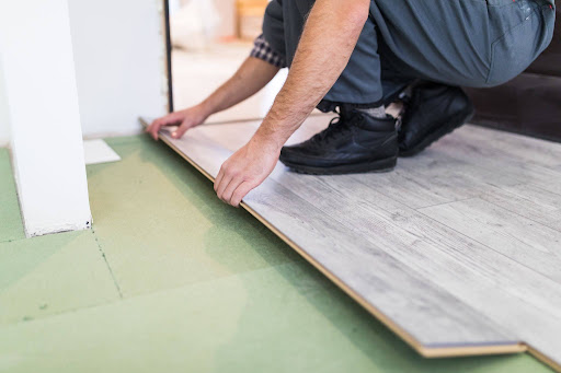 Professional installing click-lock SPC flooring over existing tiled flooring. 